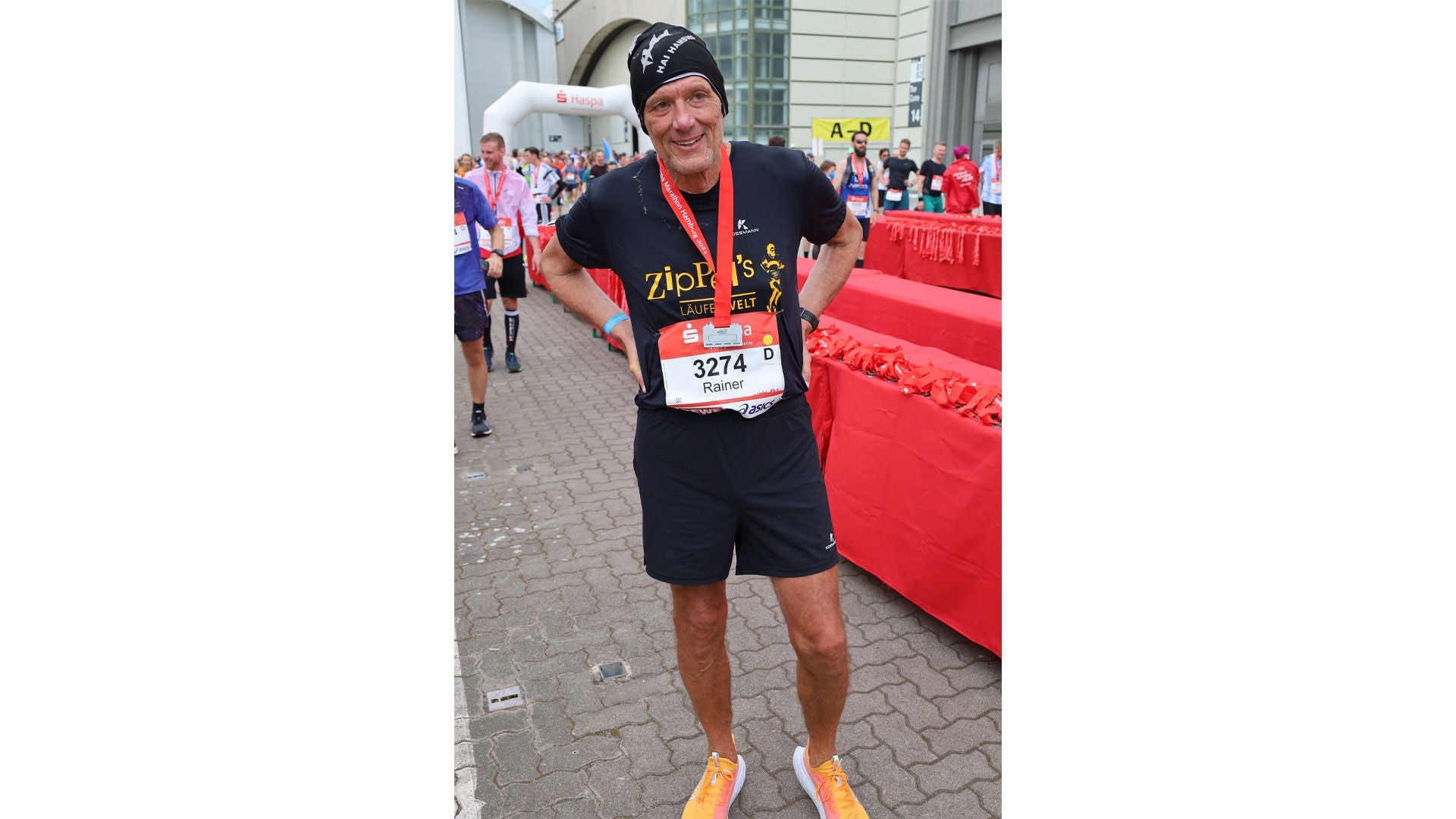 Rainer Ziplinsky steht in T-Shirt und kurzen Hosen im Ziel nachdem er erfolgreich einen Marathon gelaufen ist.  Bildquelle: privat